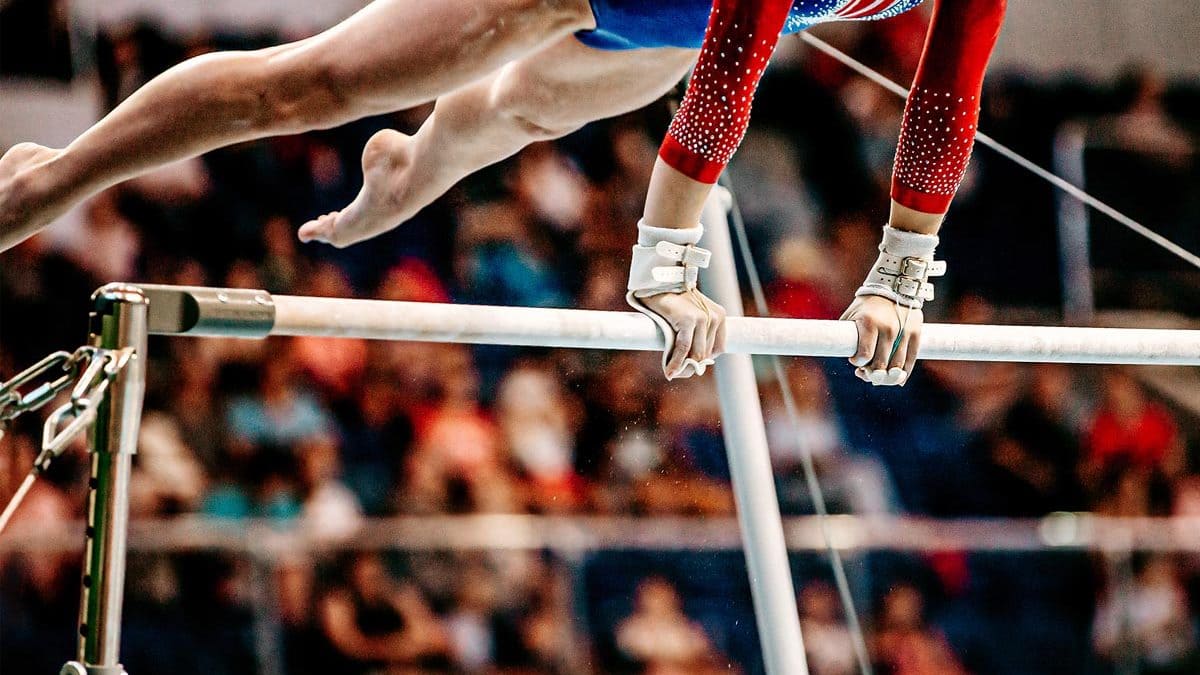 Close-Up Body Part Female Gymnast Exercise On Uneven Bars In Artistic Gymnastics, Sports Summer Games What Is Artistic Gymnastics: A Sport Of Authentic Grace